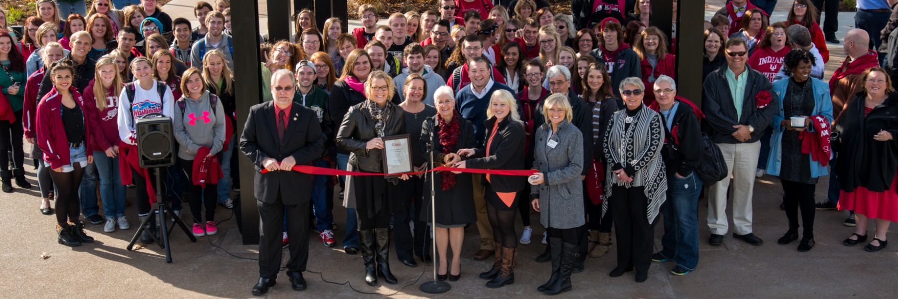 Large group of faculty, staff and students at a ribbon cutting on the quad.