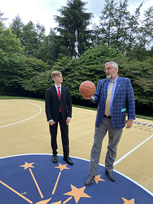 Photo of Cole Fosbrink with Gov Holcomb holding a basketball