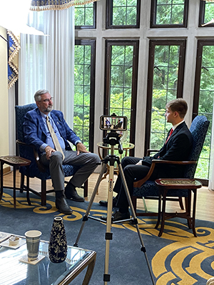 Photo of Gov Holcomb sitting in his office interviewed by Cole Fosbrink